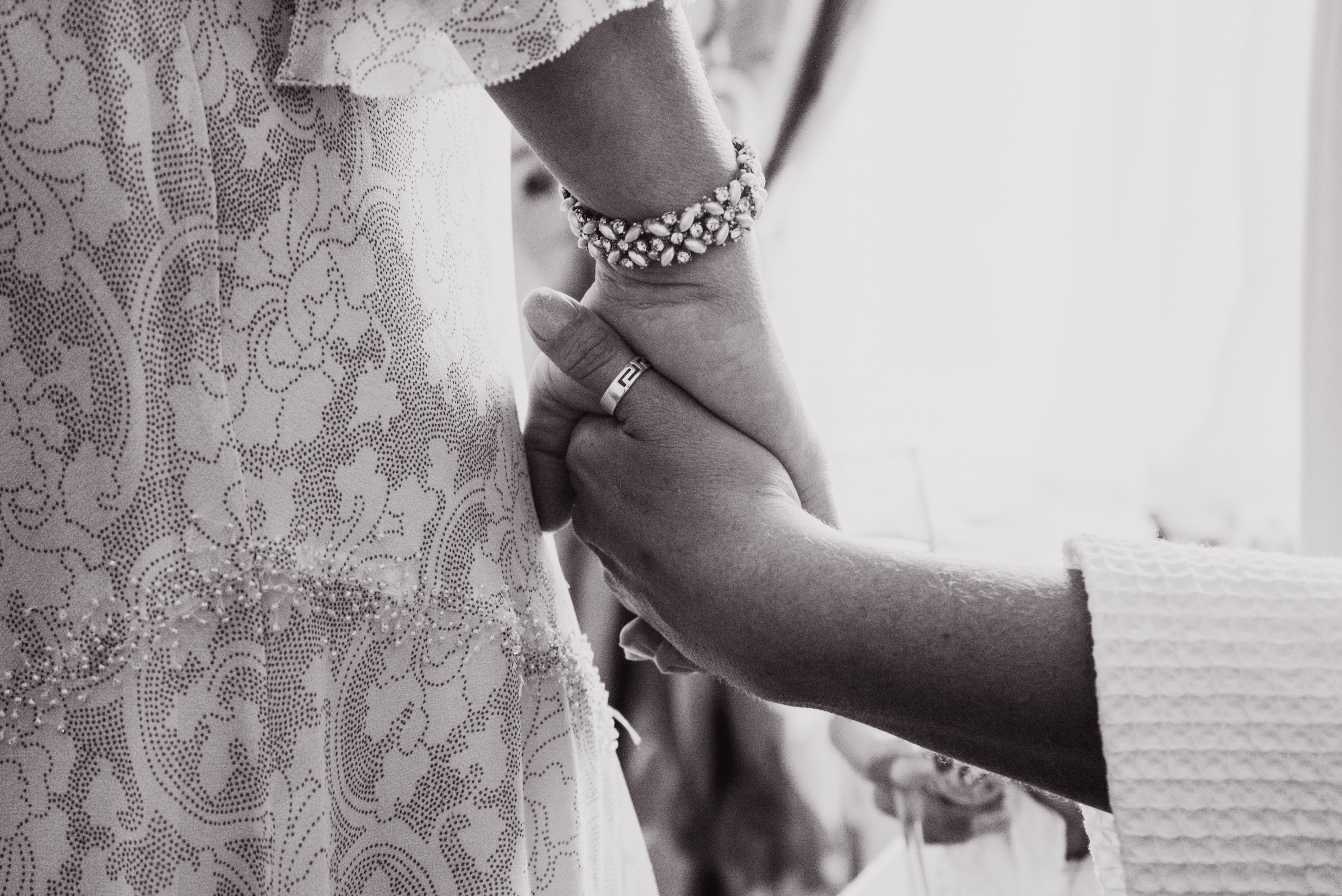 mum holding hands with bride