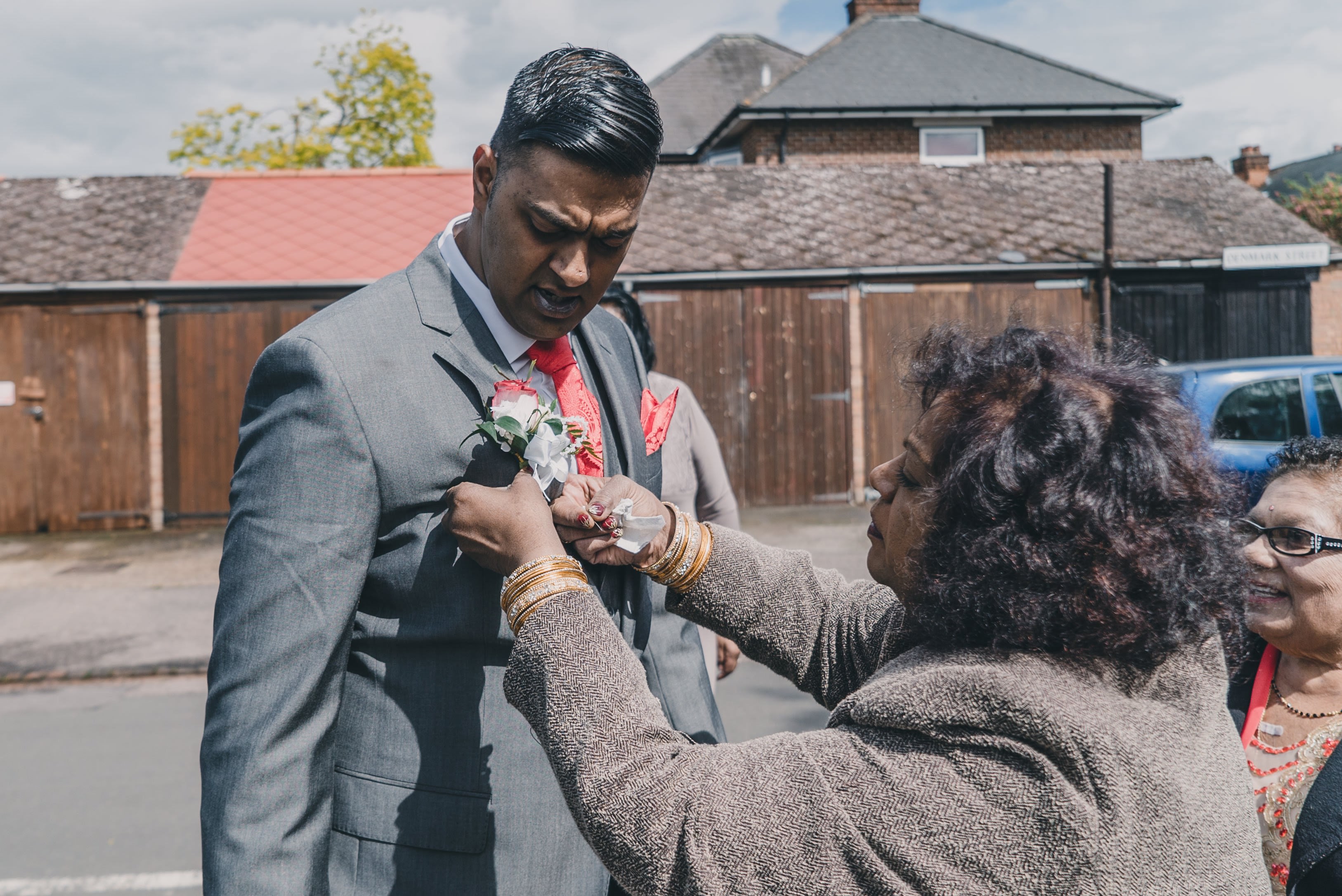grooms mother putting flower on groom