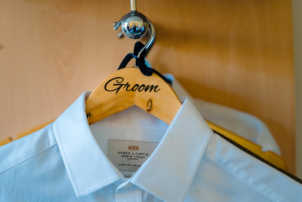 Wooden groom hanger with white dress shirt, wedding day