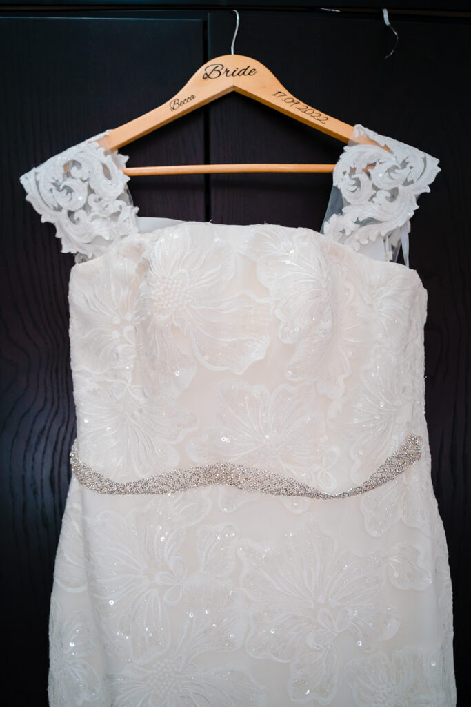 Elegant white bridal gown on personalised wooden hanger