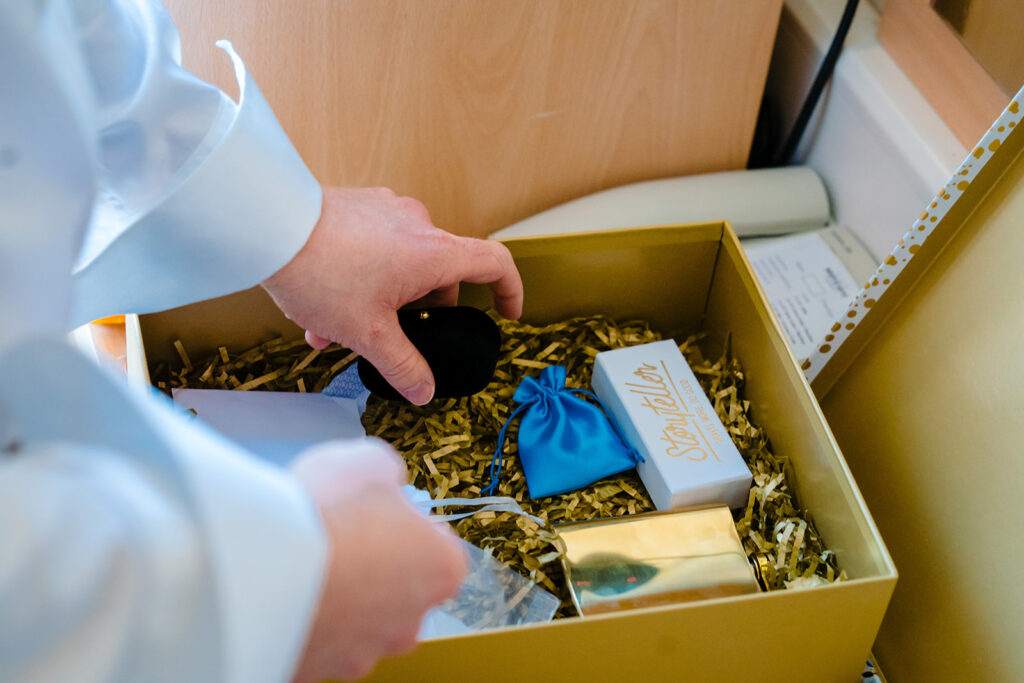 Child's hand opening luxury gift box with straw packaging