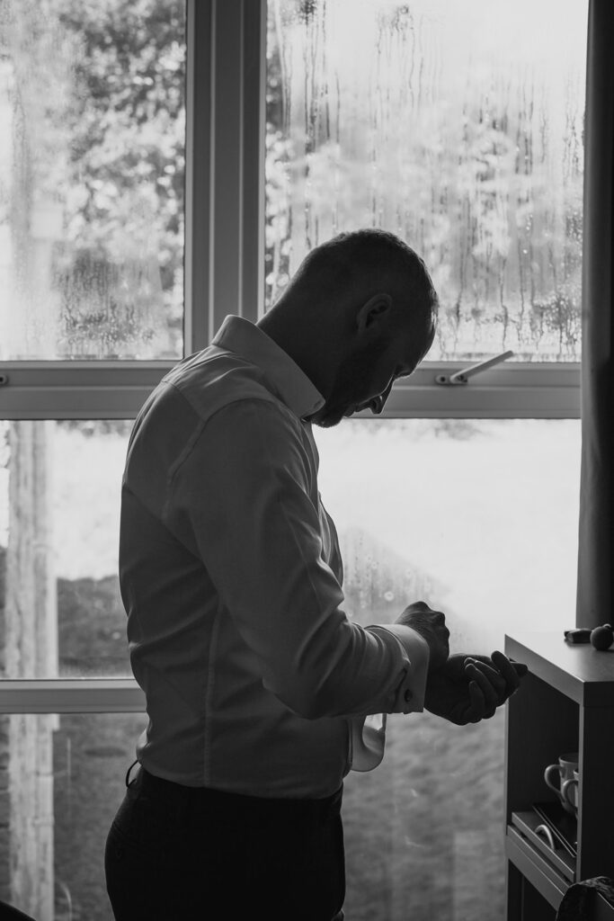 Man looking at phone by frost-covered winter window