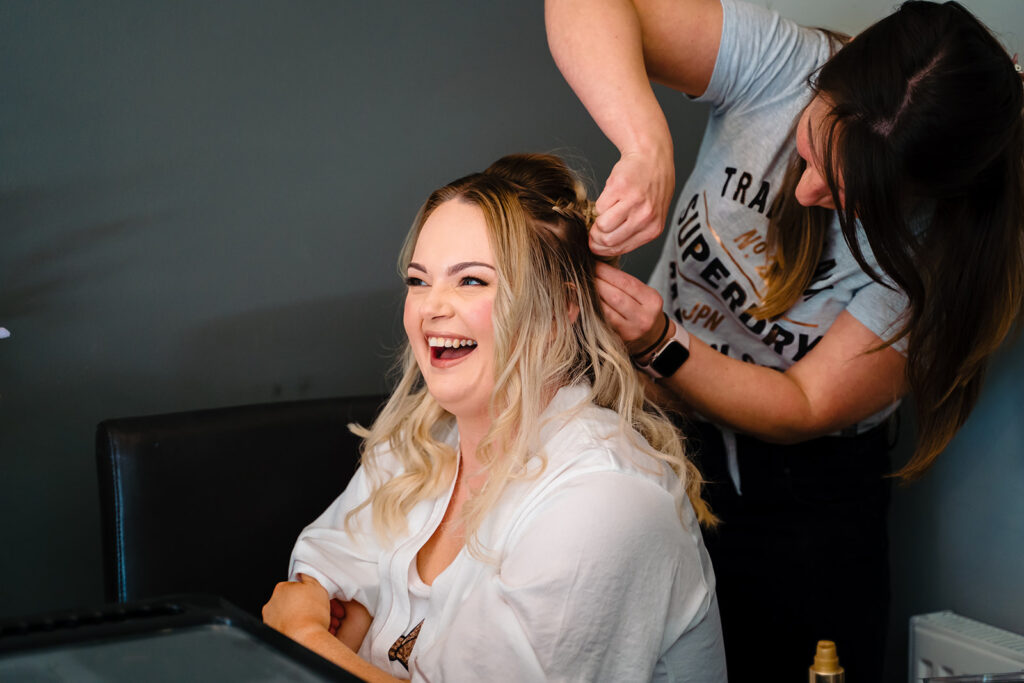 Hairdresser styling blonde woman's hair in salon