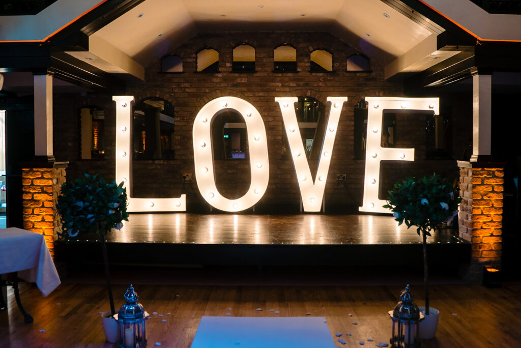 Large illuminated LOVE sign at elegant event venue