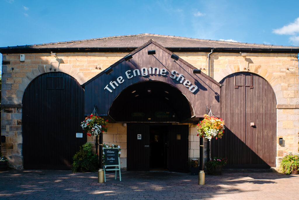 The Engine Shed building entrance with arched doors and flowers