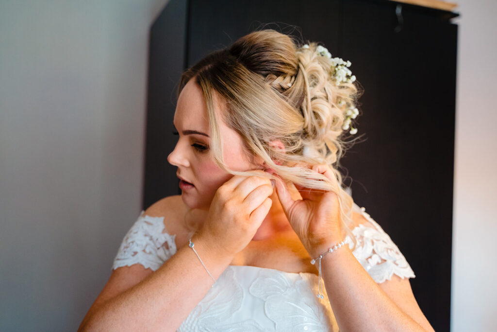 Bride adjusting veil with floral hair accessory