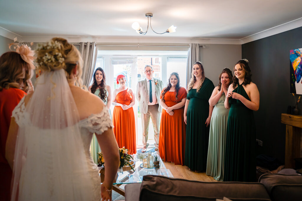 Bride in white dress showing guests her wedding gown indoors