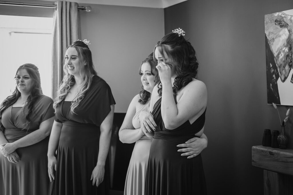 Four women in formal dresses wearing floral hair accessories indoors