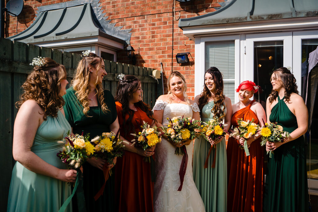 Bride with bridesmaids holding yellow flowers at wedding
