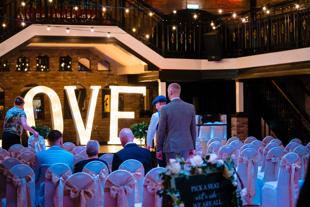 Wedding ceremony setup with LOVE sign and decorated chairs