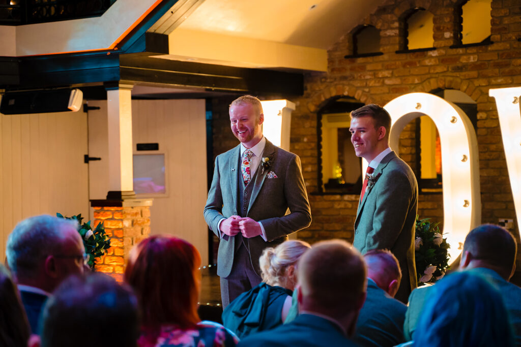 Two men in suits speaking at wedding celebration event