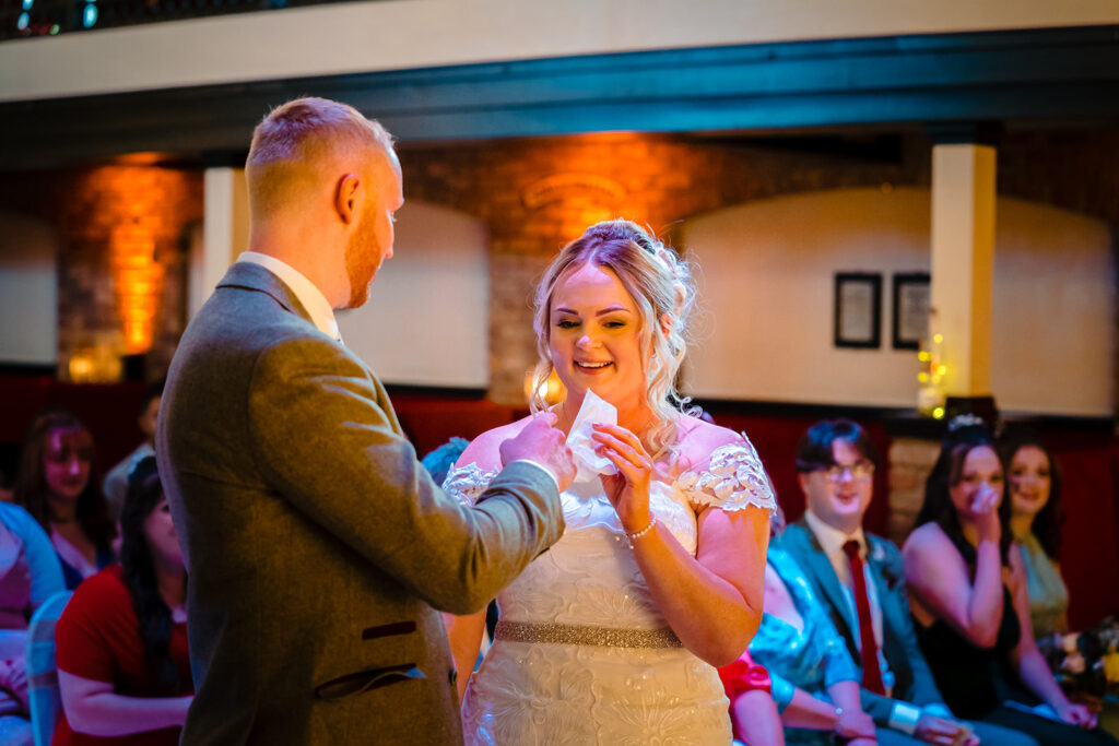 Bride and groom dancing at wedding reception with guests watching