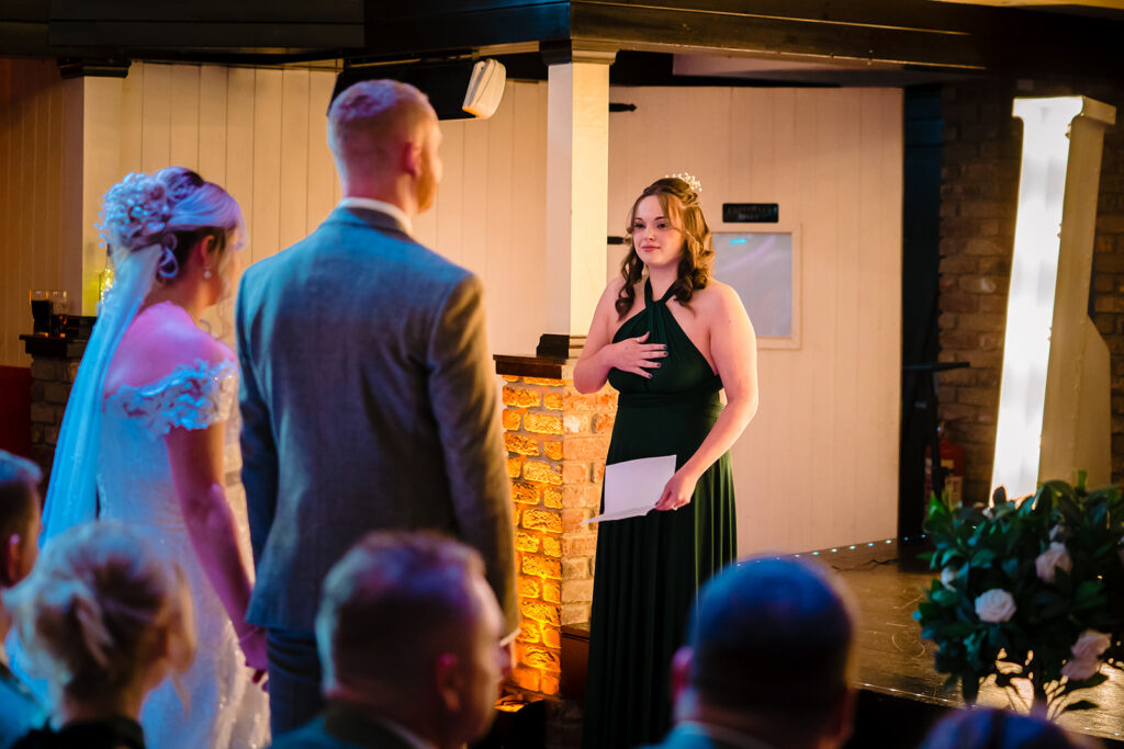 Wedding ceremony officiant speaking to bride and groom indoors