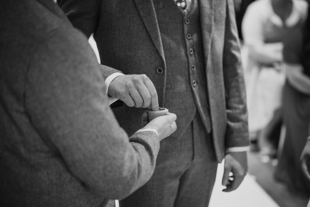 Child's hand holding adult's finger in black and white