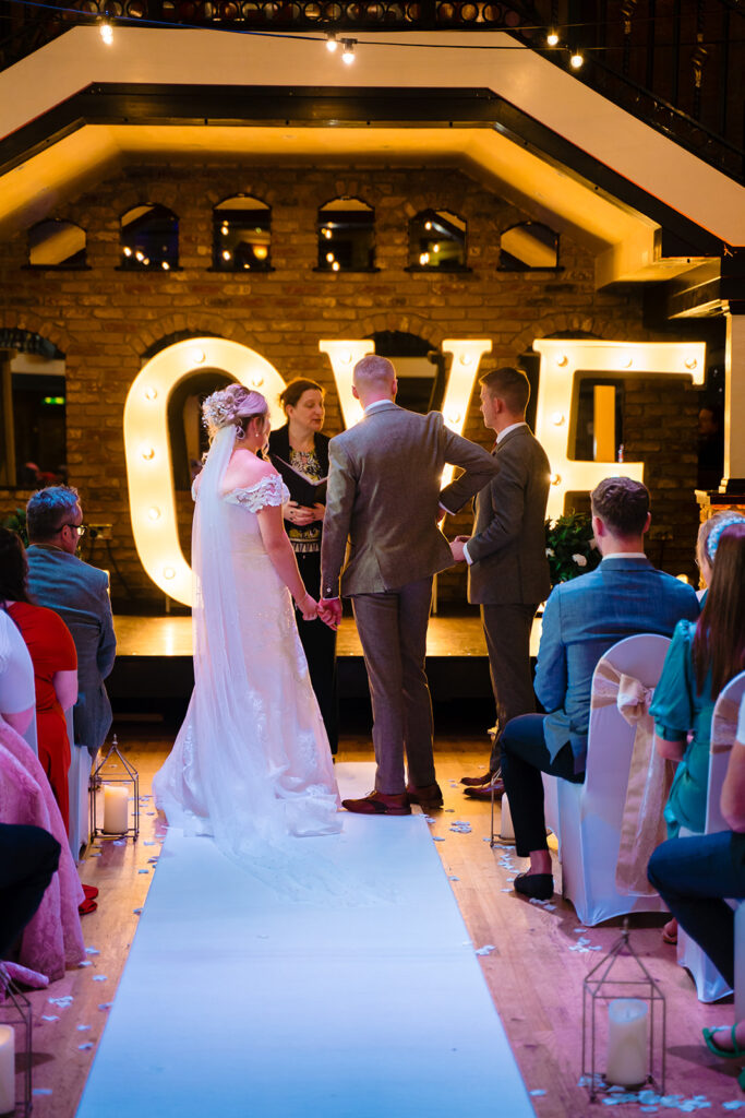 Bride and groom exchanging vows at indoor wedding ceremony