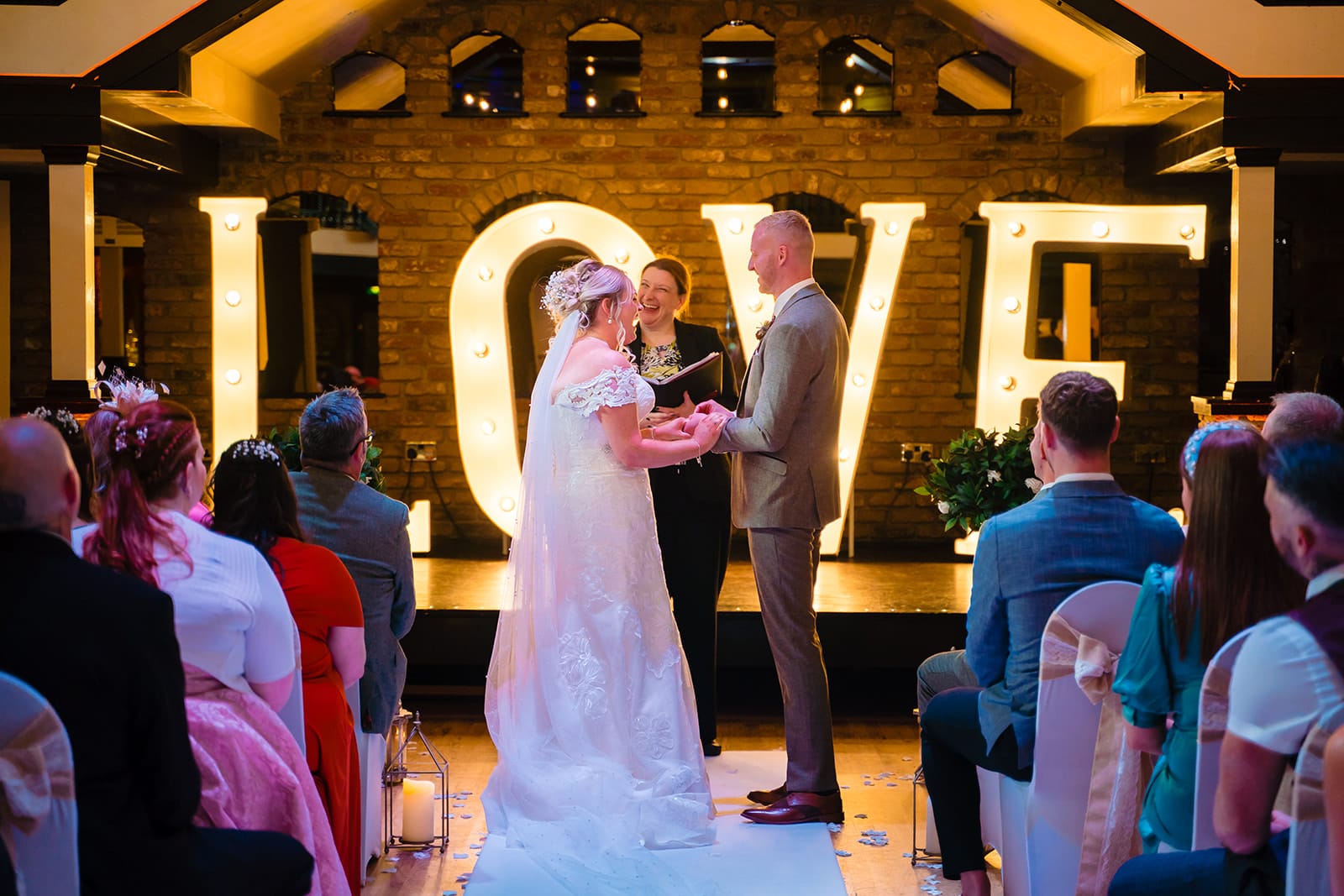 Wedding ceremony with bride, groom, and guests indoors