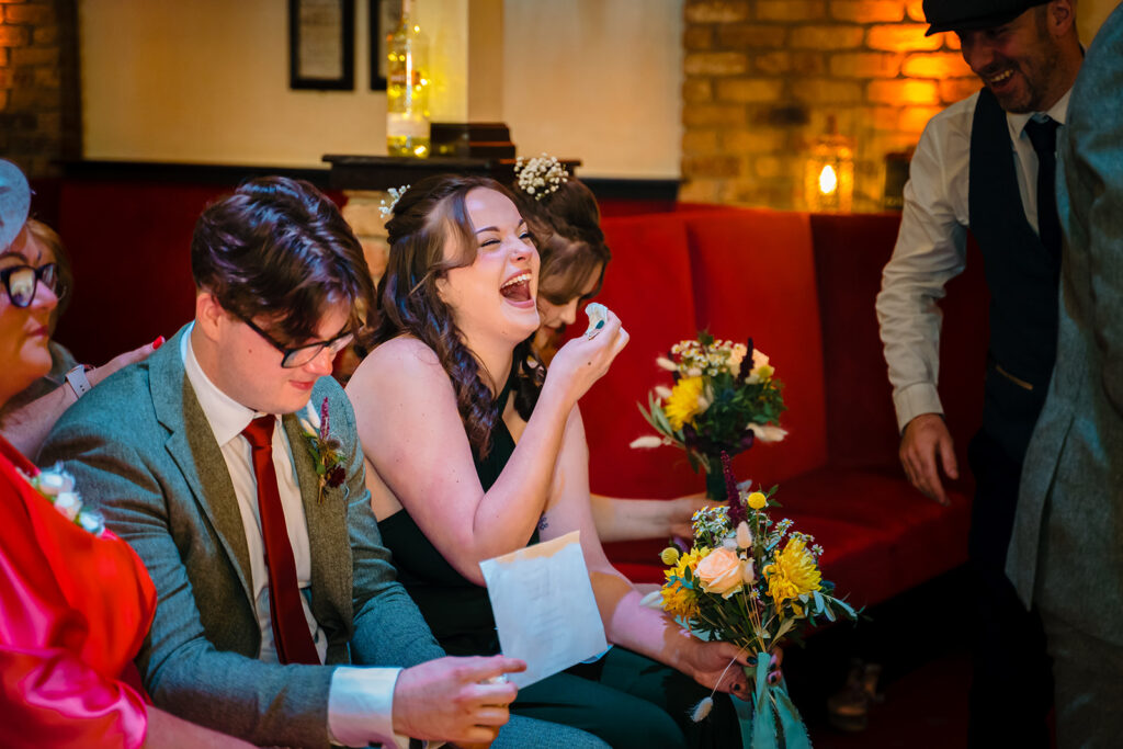 Wedding guest laughing joyfully at indoor reception celebration