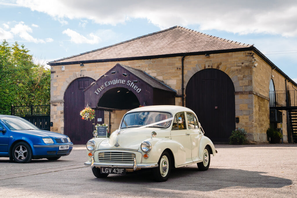 Vintage cream Morris Minor car outside The Engine Shed building