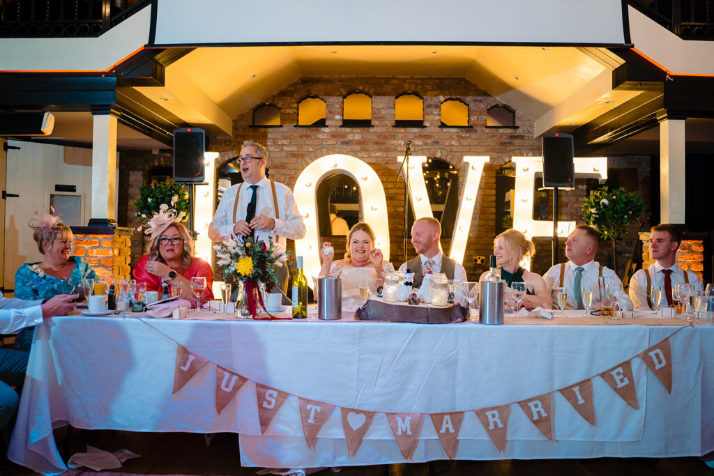 Wedding reception head table with just married banner and guests