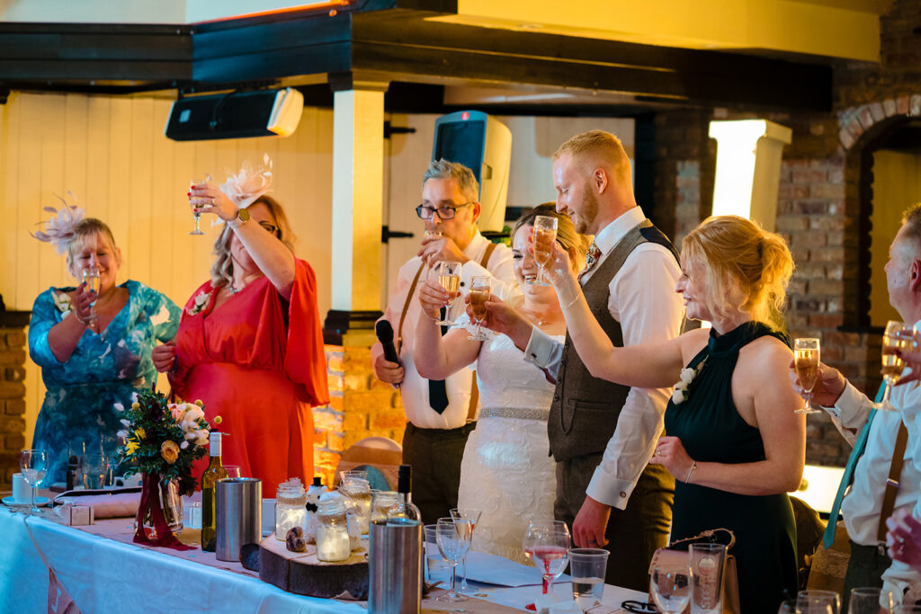 Wedding reception guests toasting with champagne glasses
