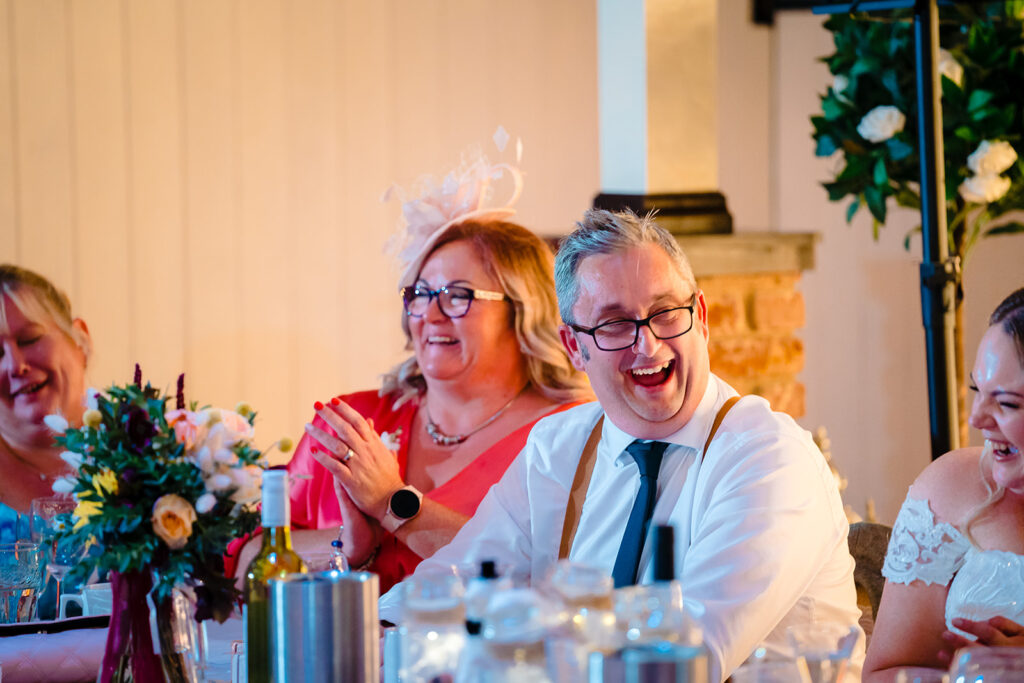 Guests laughing at formal dinner celebration event