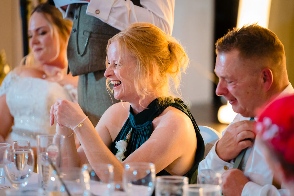 Woman laughing at wedding reception dinner table