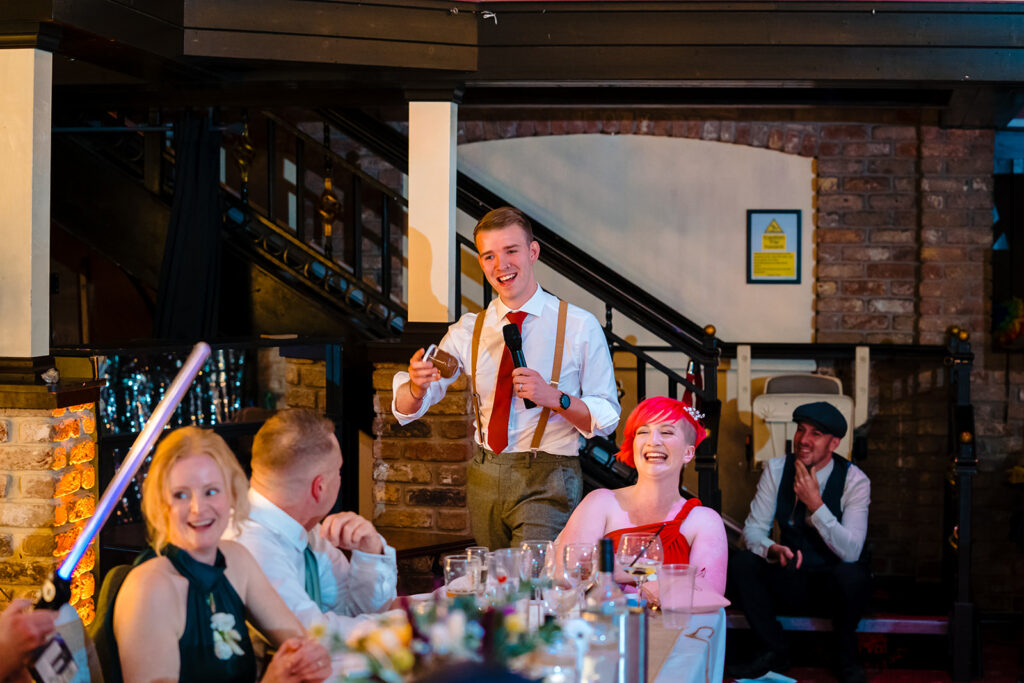 Man speaking at microphone during formal event celebration