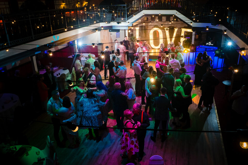 Rooftop party with colourful lighting and dancing crowd