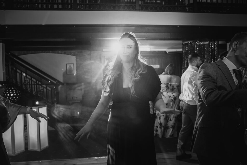 Woman in formal attire at indoor event with guests