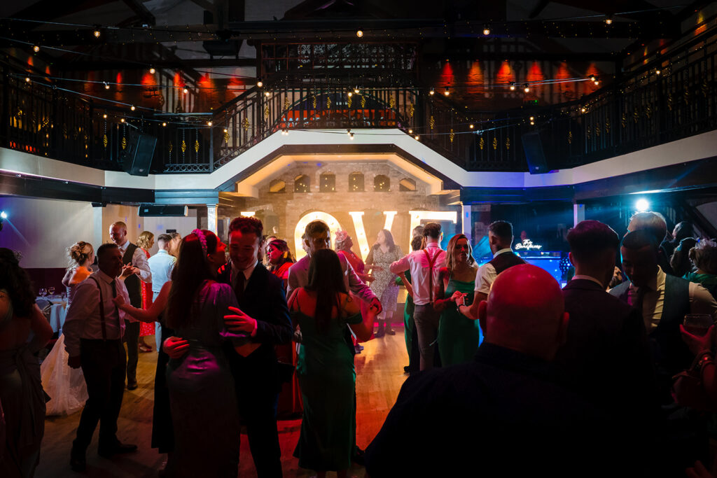 Guests dancing at elegant indoor venue with stage lighting