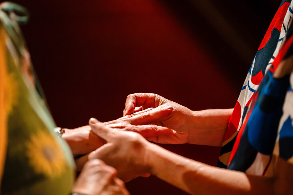 Close-up of a wedding ring being placed on a finger during Beverly and Jane's ceremony