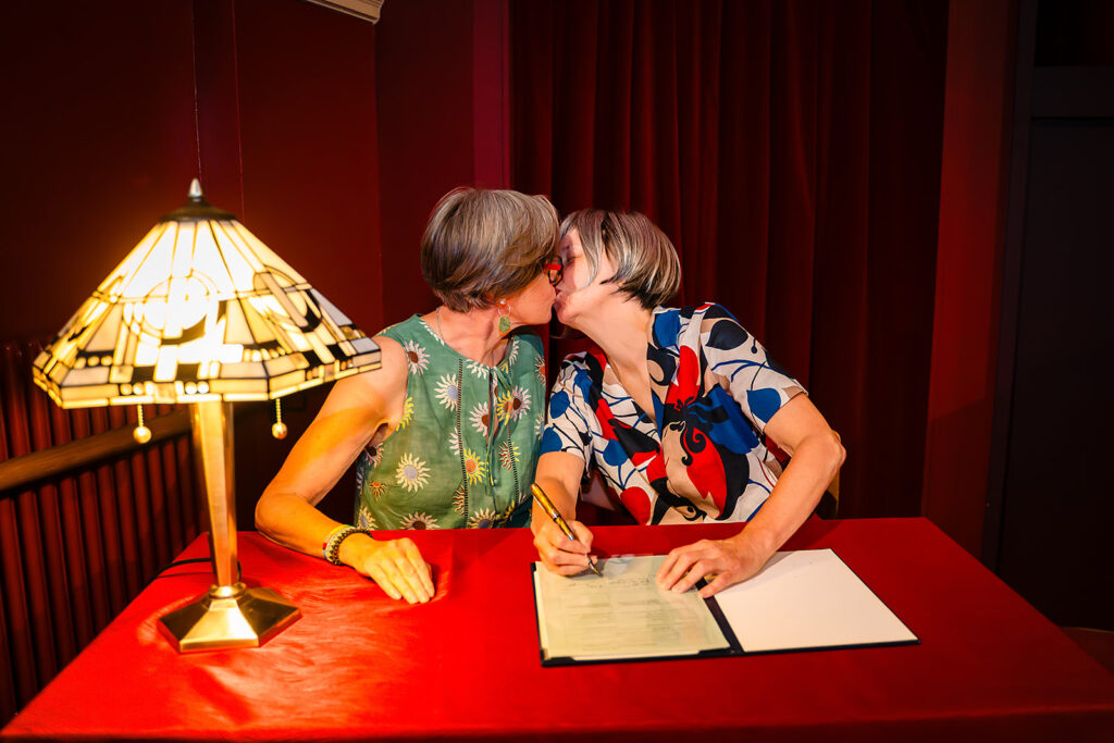 Beverly and Jane kissing as they sign the register at the Hyde Park Picture House