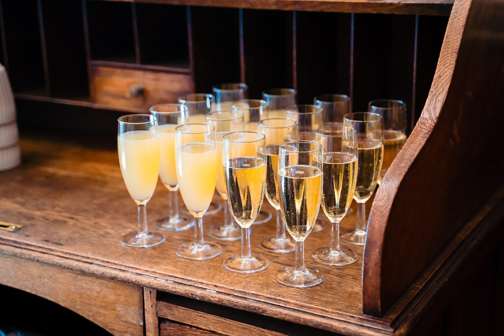 Glasses of fizz and orange juice lined up on a wooden counter in the Hyde Park Picture House foyer