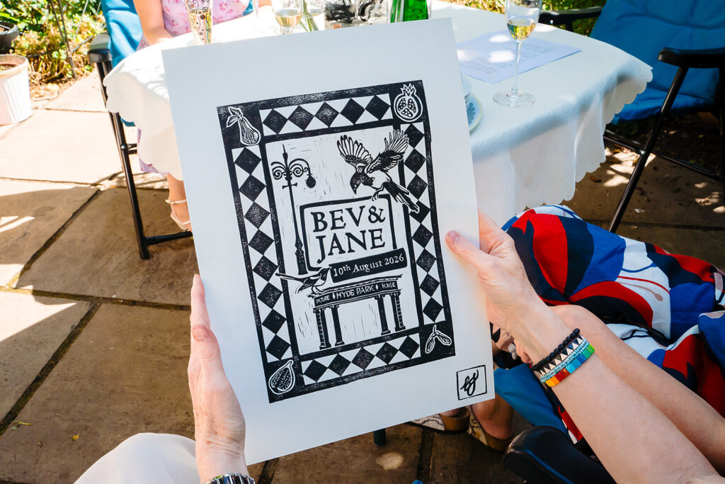 Linocut print reading Bev and Jane 10th August 2026, with magpies, figs and the Hyde Park Picture House