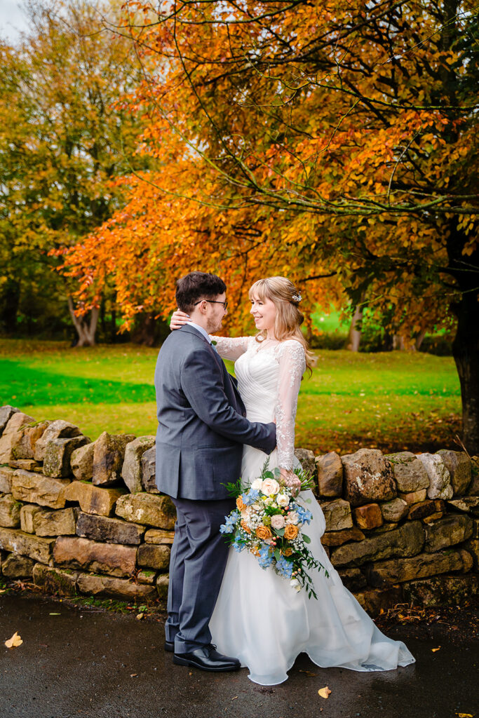 Cody and Dale smiling at each other with autumn colours behind them