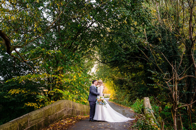 Cody and Dale kissing on a tree-lined lane near The Old Barn at Esholt