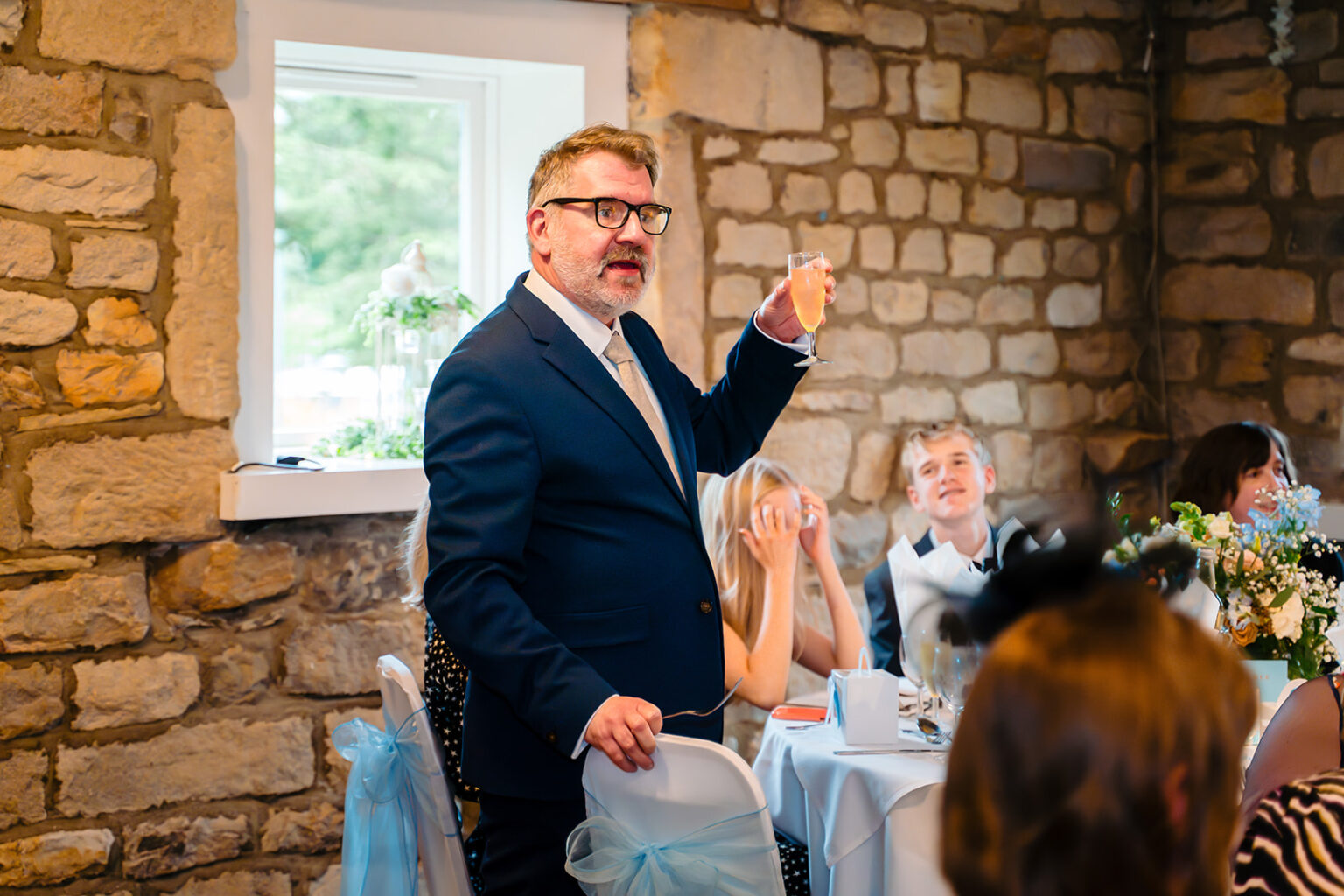 A guest raising a glass during the speeches at The Old Barn at Esholt