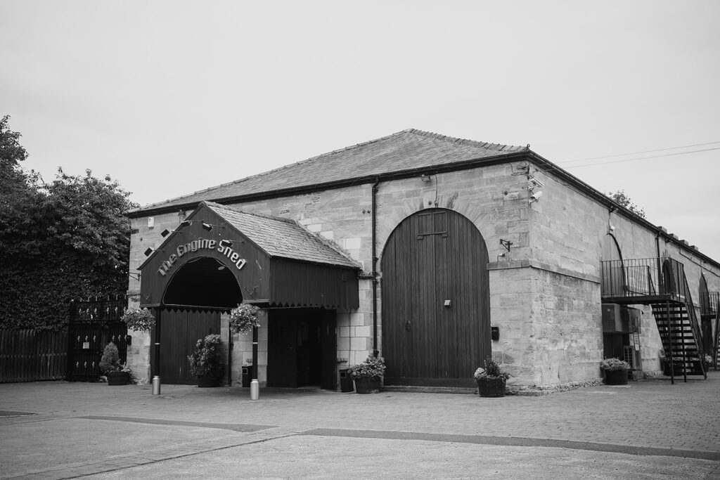 Historic stone distillery building with dark wooden doors and arched entrance