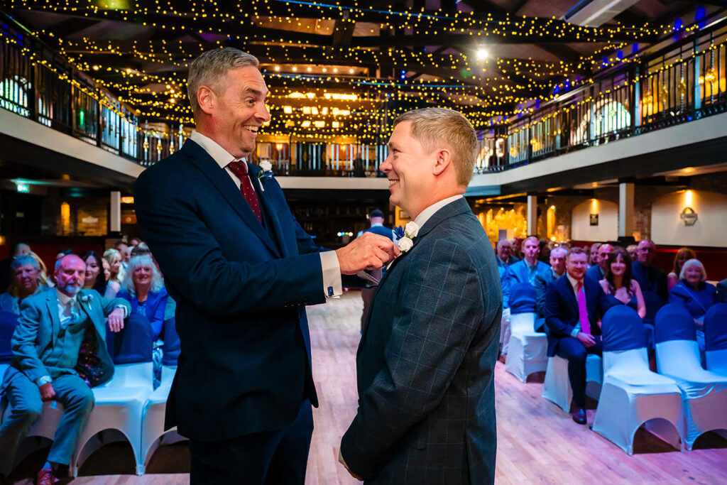Two men shaking hands at festive gala event with audience