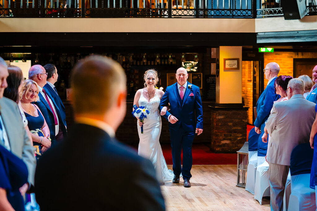 Bride and groom walking down aisle at wedding reception
