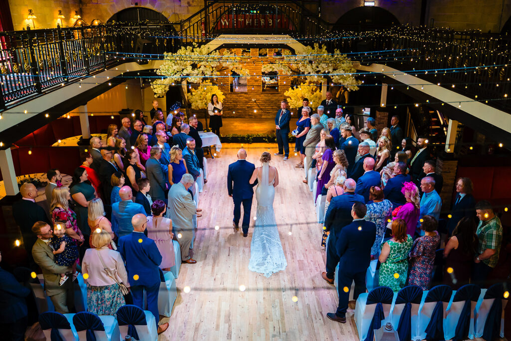 Bride and groom walking down aisle at elegant wedding reception