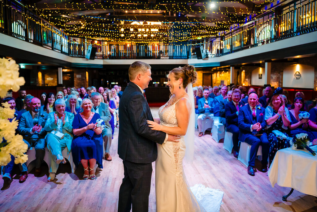 Bride and groom dancing at elegant wedding reception with guests