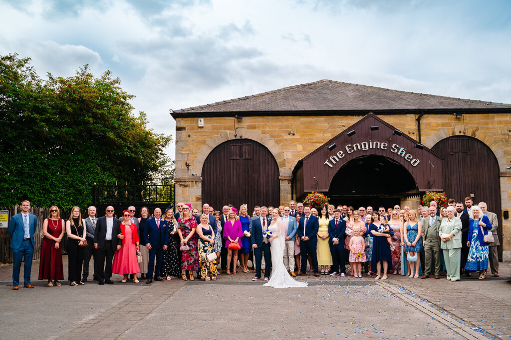 Large wedding group photo at historic engine shed venue
