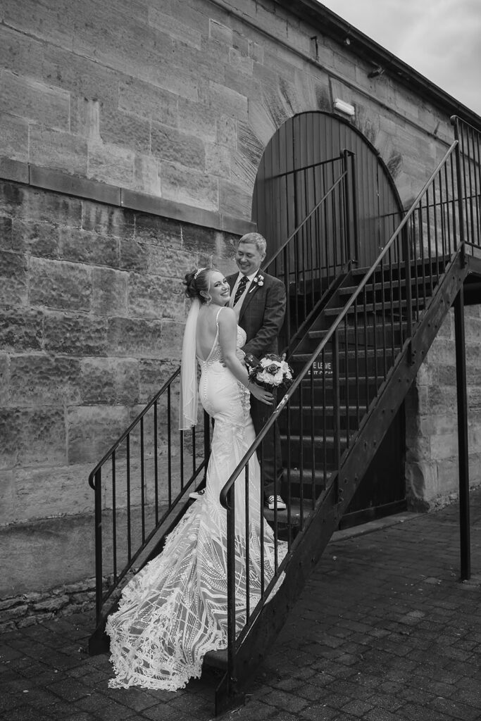 Bride and groom on stone staircase black and white wedding