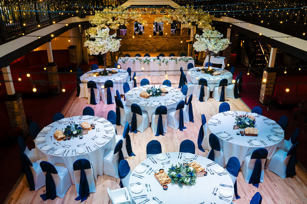 Elegant wedding reception ballroom with round tables and floral arrangements