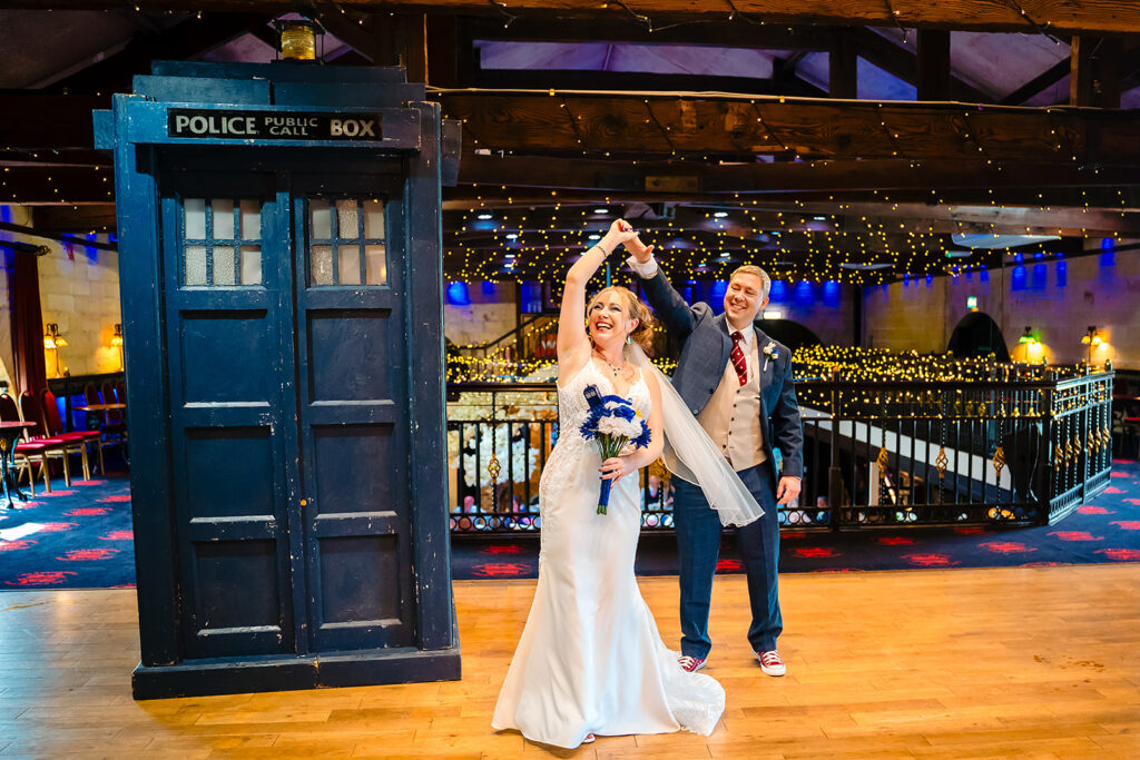 Nena twirling under David's arm next to a full-size TARDIS on the mezzanine at the Engine Shed, Wetherby