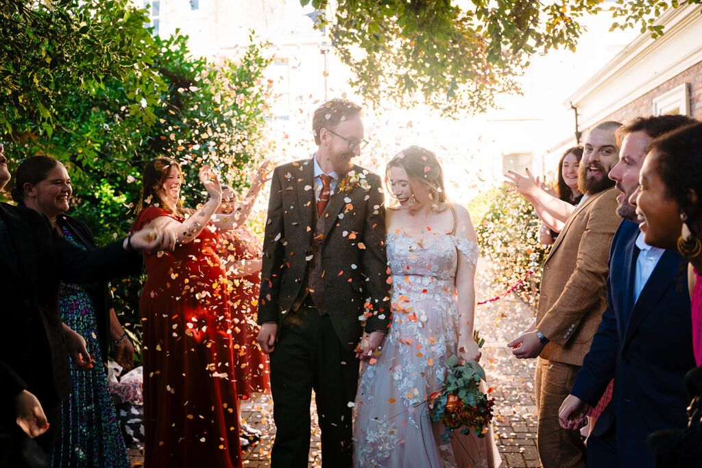 Newlyweds celebrating with confetti and guests at wedding ceremony