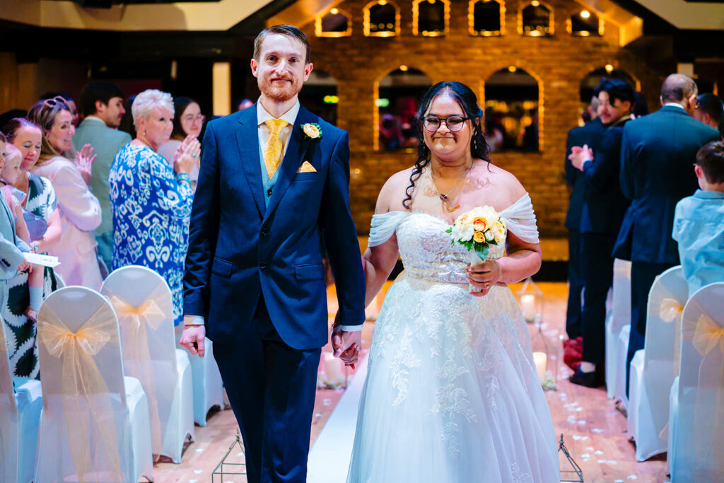 Fran and Andy walking back up the aisle together as newlyweds at the Engine Shed, Wetherby