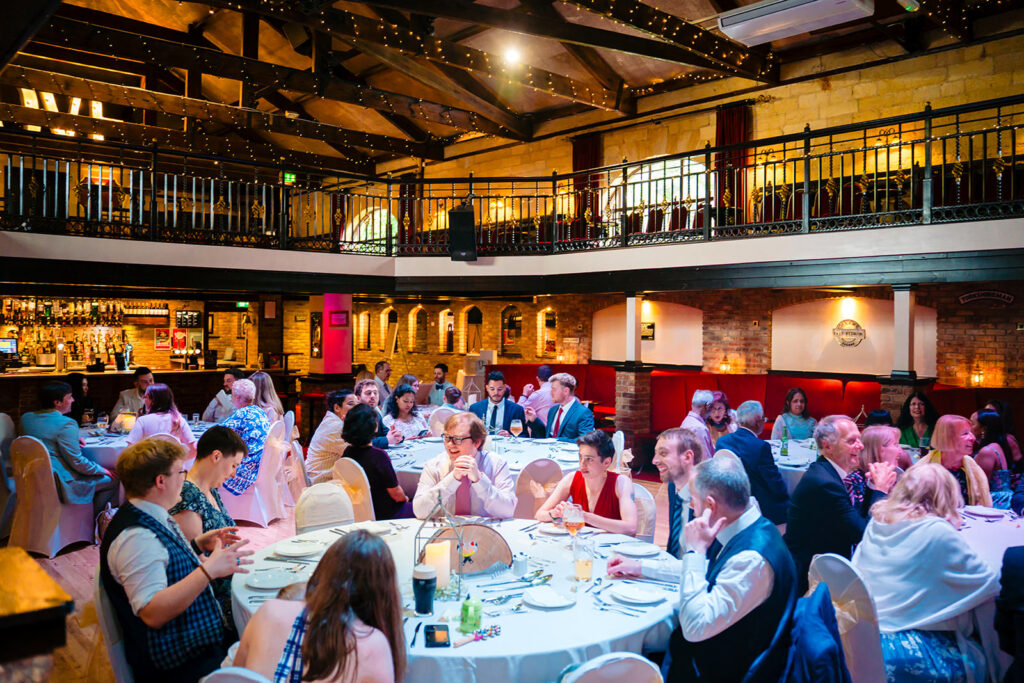Guests laughing at their table during the wedding breakfast at the Engine Shed