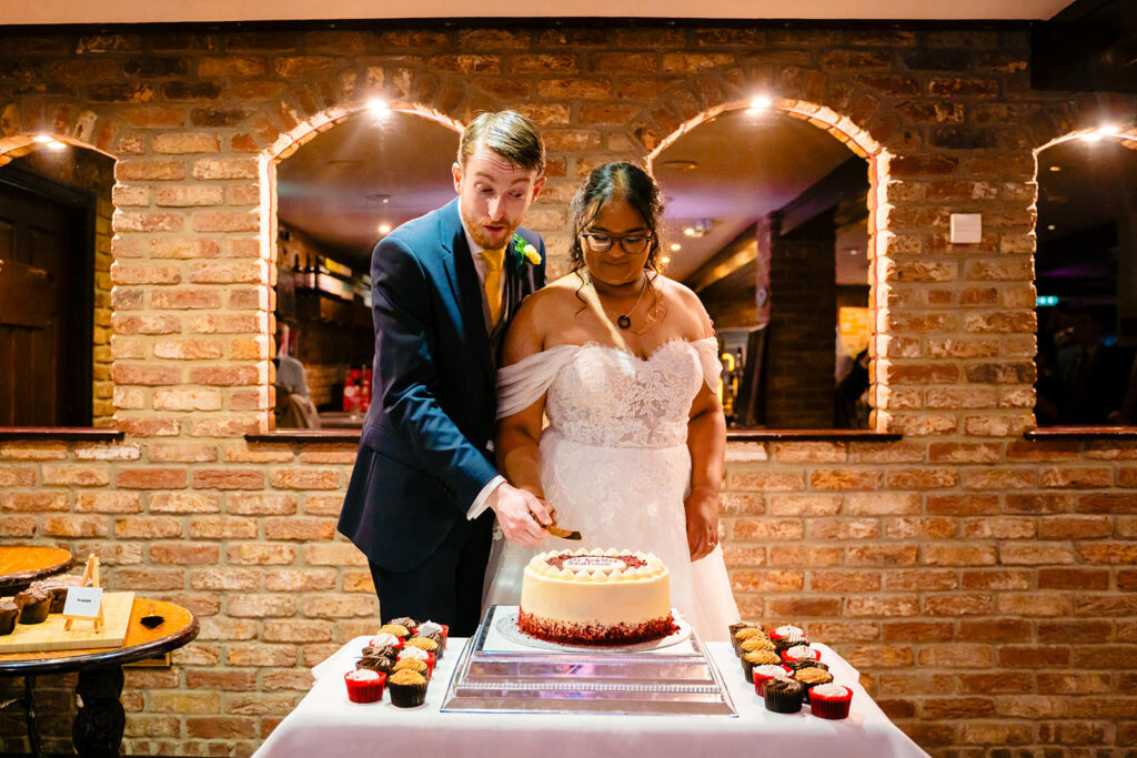 Fran and Andy cutting their Mr and Mrs Goldfinch red velvet cake at the Engine Shed